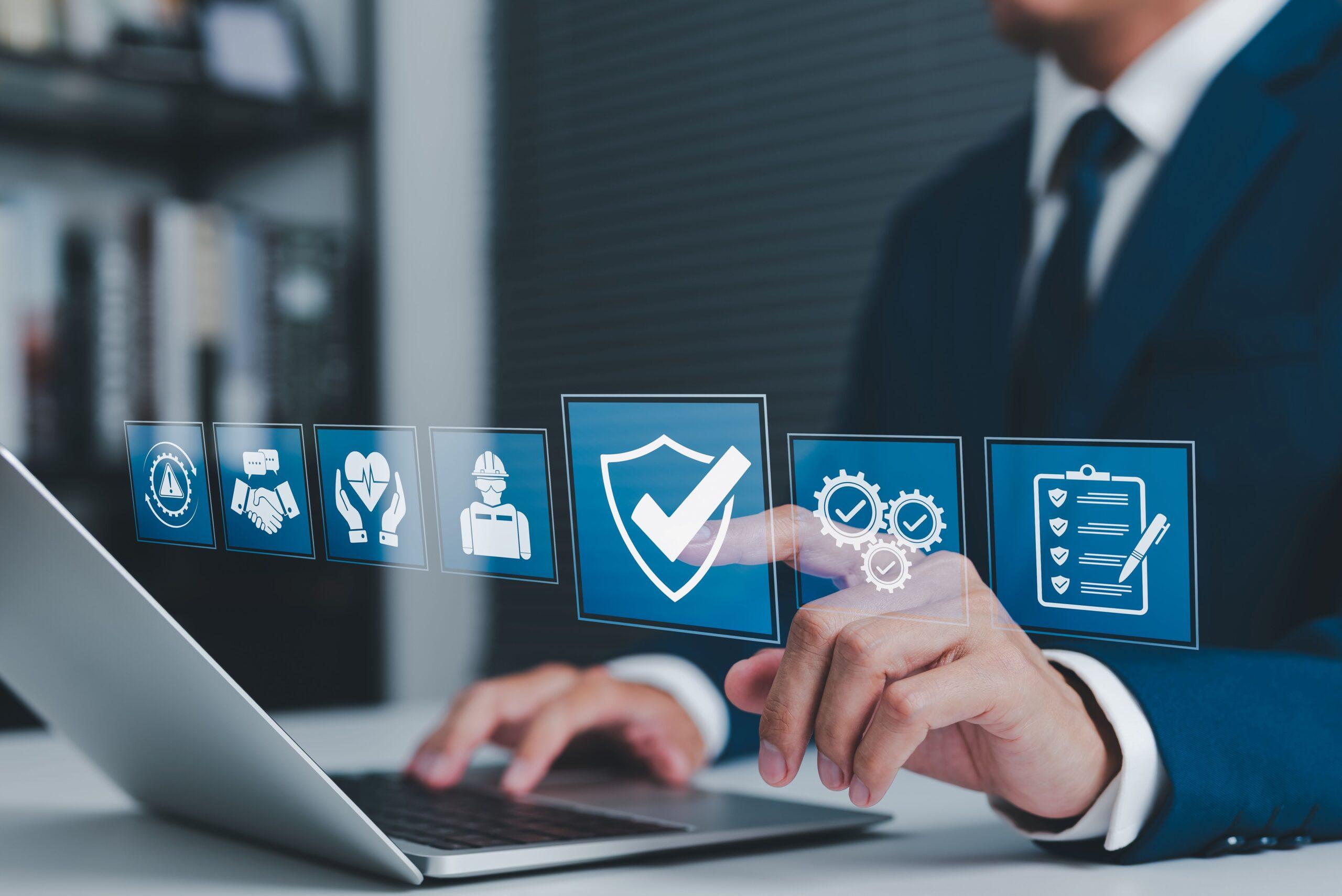 Führungskraft am Laptop mit digitalen Symbolen für Sicherheit, Prävention und Mitarbeiterschutz